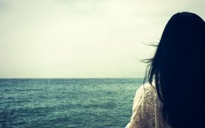 photo of a girl looking out at the ocean